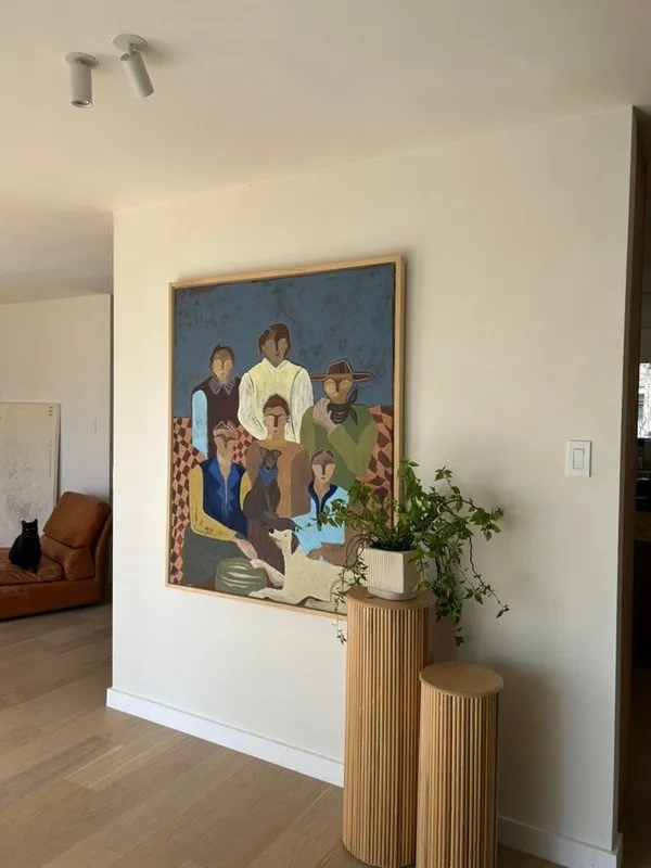 The Hold My Hand painting hung in a bright hallway above a fluted wooden plinth.